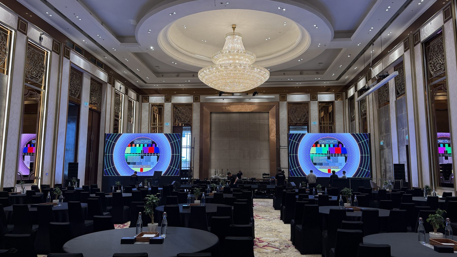 The Global Tech Summit ballroom set with chandeliers, LED wall and dressed rounds