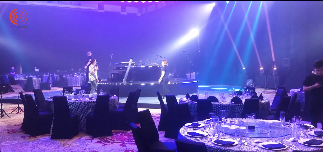 Dance floor lit in blue and pink beams in full swing at the gala