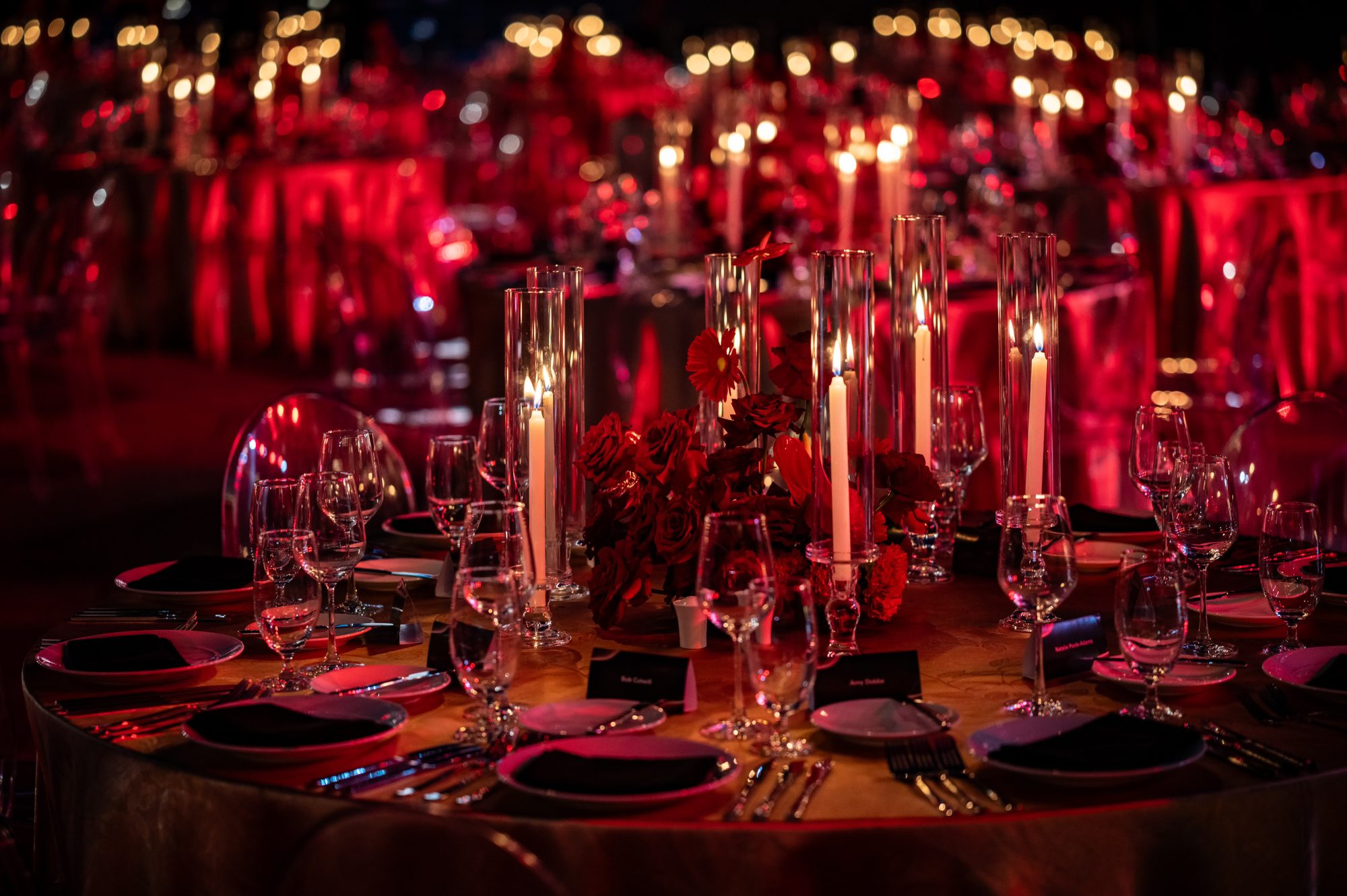 Candlelit gala table with red florals and crystal glassware