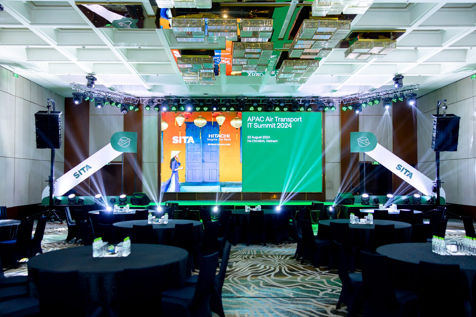 Full plenary set with a wide green-lit LED wall and SITA sail banners