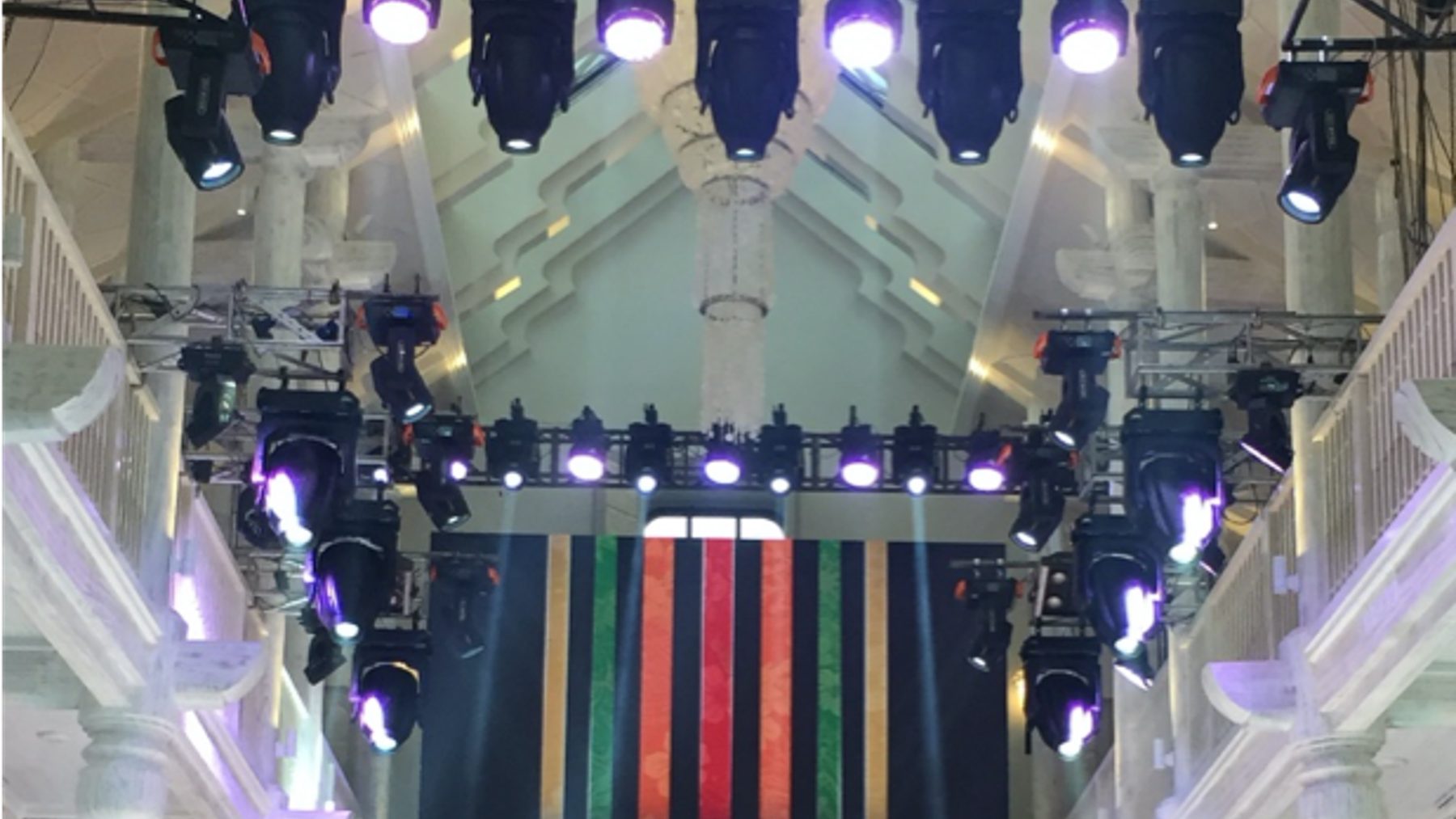 A New Beginning stage backdrop with striped panels under the circular truss