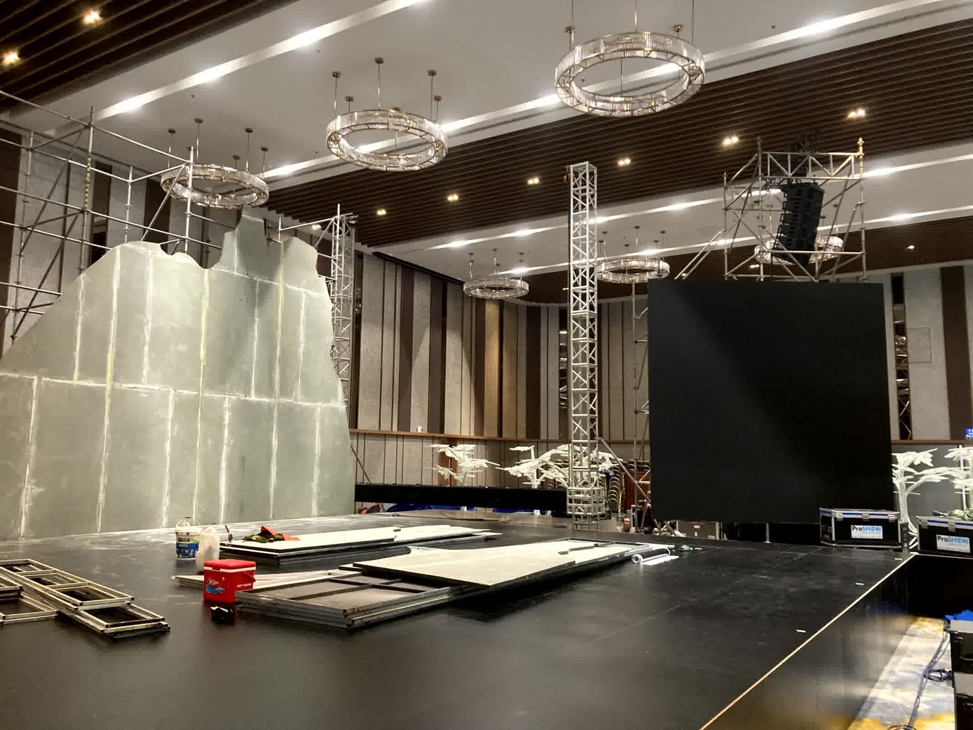 Crew rigging stage lighting and truss during an event build